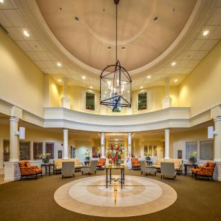 A spacious and well-lit lobby featuring modern seating and an elegant chandelier.
