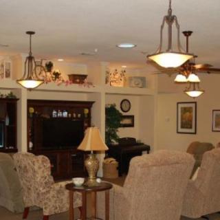A cozy living room with comfortable seating, warm lighting, and a television.
