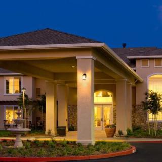 A well-lit building entrance at night with architectural columns.
