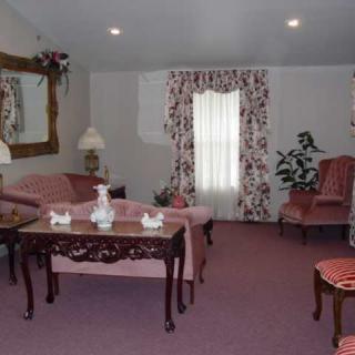 A vintage-style living room with pink furniture and floral accents.