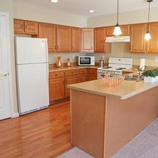 A cozy kitchen with wooden cabinets and a central island featuring modern appliances.