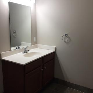 A modern bathroom featuring a simple vanity with a sink and mirror.