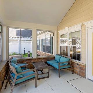 A cozy patio with outdoor seating and large windows.
