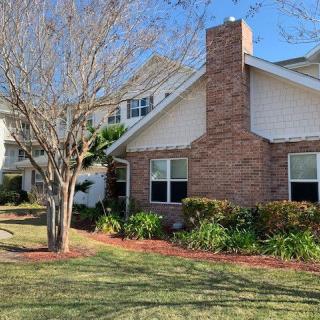 A suburban house with a brick chimney and well-maintained yard.