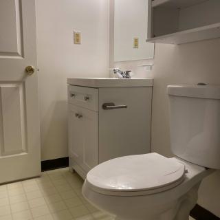 A minimalist bathroom with a toilet and sink.