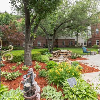 A beautifully landscaped garden with lush greenery and a peaceful seating area.