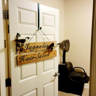 An interior view of a hair salon with a wooden sign on the door.