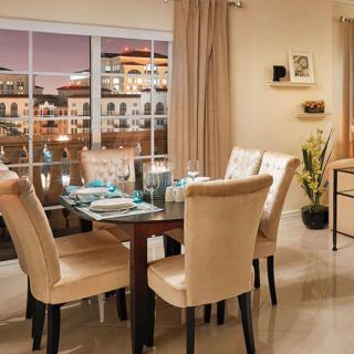 A modern dining room with a beautifully set table and a stunning city view.
