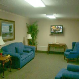 A cozy living room with blue sofas, a wall-mounted television, and elegant decor.