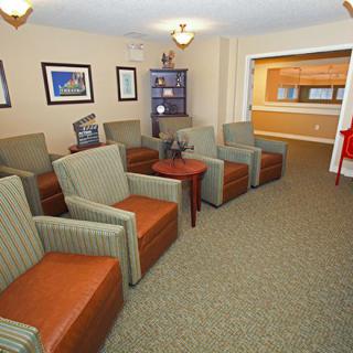 A cozy waiting room with multiple chairs and a reception desk.