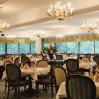An elegant dining room with chandeliers and neatly arranged tables and chairs.