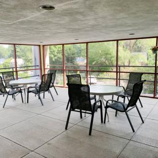 A screened patio area with tables and chairs arranged for outdoor seating.