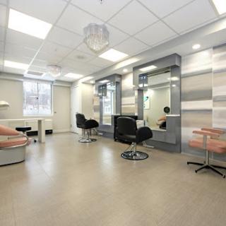 A modern and minimalist beauty salon interior featuring stylish chairs and large mirrors.