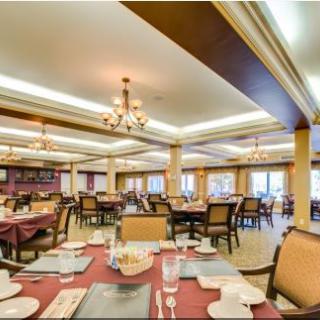 An elegant dining area with neatly arranged tables and chandeliers.