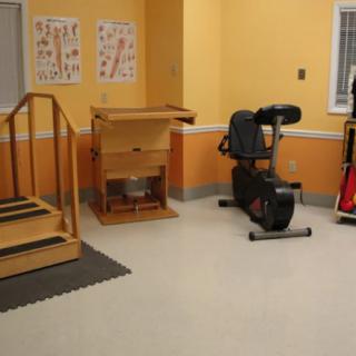 A physical therapy room with exercise equipment and stairs for rehabilitation exercises.