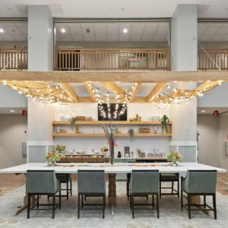 A modern open kitchen with a central island bar, stylish lighting, and contemporary seating.