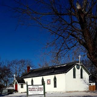 A quaint white church set against a bright blue winter sky.