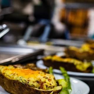A dish featuring a cheesy stuffed potato served on a plate.