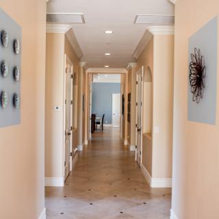 A modern hallway adorned with contemporary artwork and leading to a distant room.