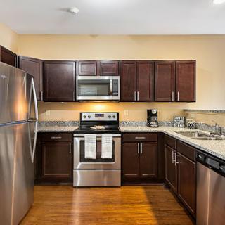 A modern kitchen featuring stainless steel appliances and elegant wooden cabinetry.