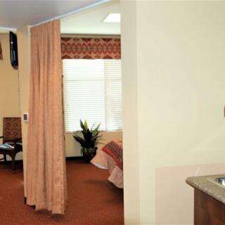 A hospital room with a curtain divider and a bed near the window.