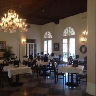 An elegant restaurant dining area with neatly arranged tables and a grand chandelier.
