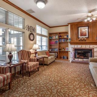 A cozy living room featuring comfortable seating, a fireplace, and bookshelves.