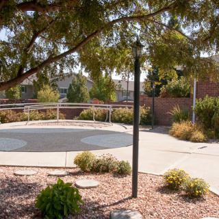 A peaceful park area with a pathway, surrounded by trees and plants.