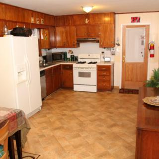 A spacious kitchen with wooden cabinets and modern appliances.