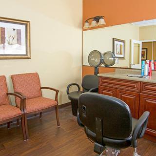 A cozy hair salon interior with styling chairs and a mirror.
