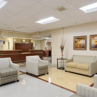 A modern lobby with a reception desk and comfortable seating, featuring sofas and armchairs.