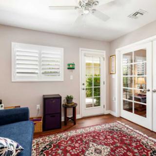 A cozy living room featuring a comfortable seating area, hardwood floors, and natural light streaming through the windows.