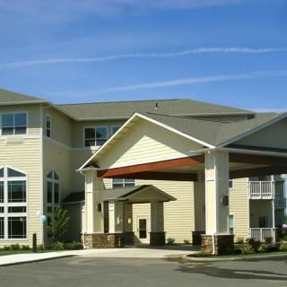 A modern residential building with a large entrance and multiple windows.