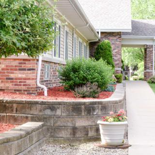 A well-maintained residential pathway with landscaping and potted plants.