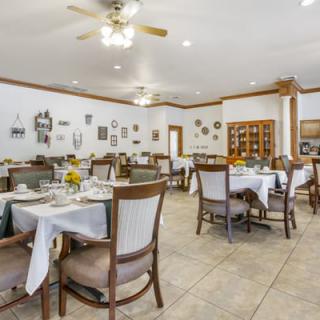 A well-lit restaurant dining area with neatly arranged tables and chairs.