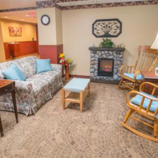 Cozy living room with a floral couch, rocking chairs, and a fireplace.