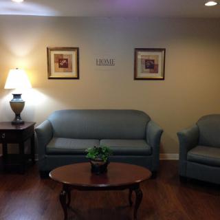 A cozy living room setup with a sofa, armchair, table, and decor.