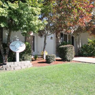 A charming home with a well-maintained front yard and colorful trees.