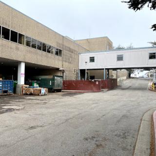An industrial area featuring a concrete building and a connecting walkway.