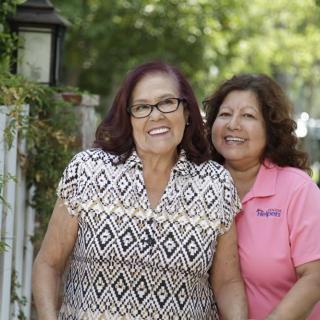 Two women smiling together outdoors.