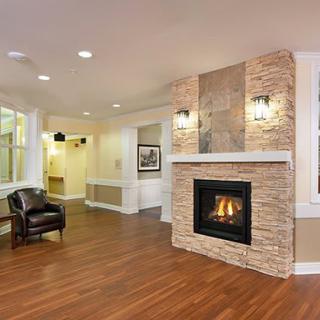 A modern living room with a cozy fireplace and stylish wood flooring.