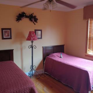 A cozy bedroom with two twin beds and a standing lamp.