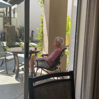A senior person enjoying a peaceful moment in the garden, soaking up the sun.