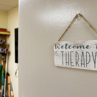A welcoming sign for a therapy room, inviting individuals to engage in healing and support.