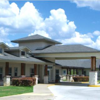 A modern residential facility under a bright blue sky.