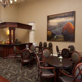 Elegant lounge area featuring artwork, a chandelier, and comfortable seating.