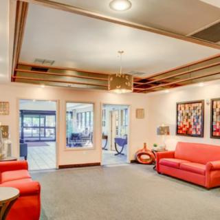 A modern lobby with vibrant red sofas and decorative artwork on the walls.