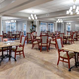 A spacious and elegantly designed dining room with multiple tables and chairs arranged neatly.