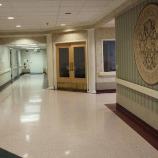 A well-lit hallway in a hospital featuring smooth flooring and decorative walls.