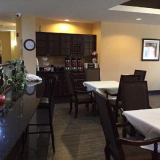 A cozy restaurant interior with neatly arranged tables and chairs, featuring a bar counter and warm lighting.